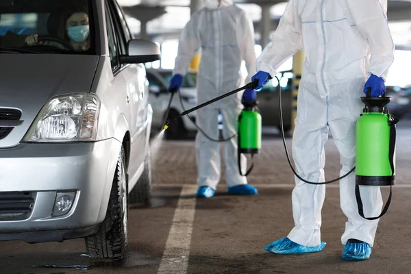 Proses desinfeksi mobil oleh pekerja dalam pakaian pelindung — Stok Foto