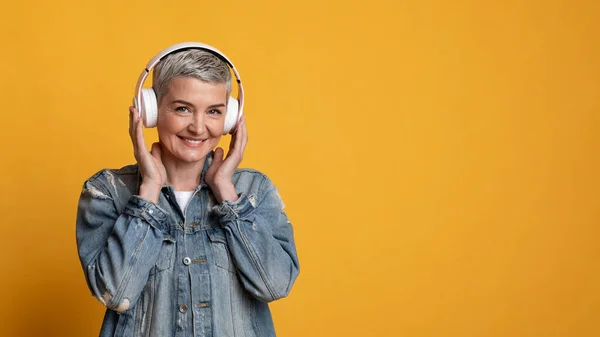 Amante da música. Retrato de mulher madura sorridente em fones de ouvido sem fio — Fotografia de Stock