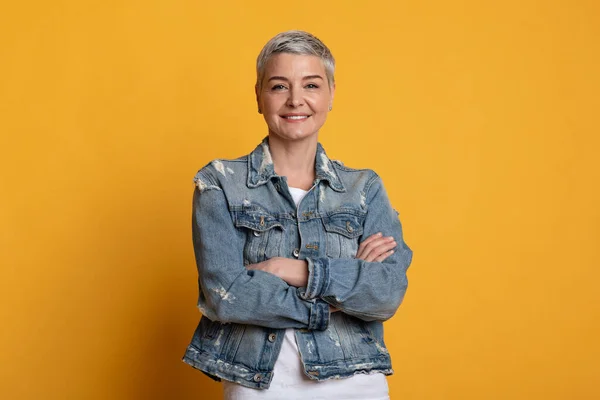 Retrato de mujer de mediana edad confiada posando con los brazos cruzados — Foto de Stock