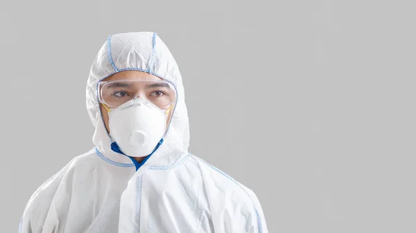 Asijský samec dezinfekce v ochranné masce, obleku a brýlích — Stock fotografie