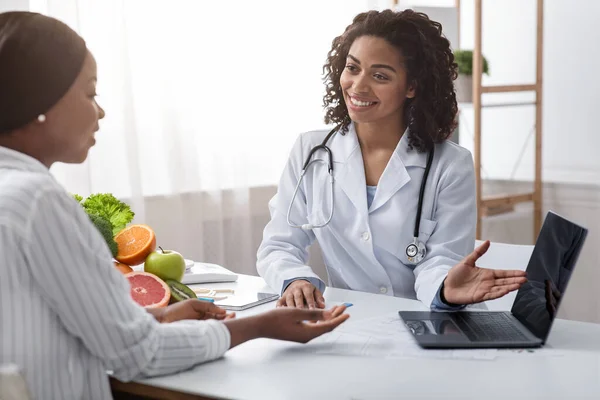 Χαμογελώντας γυναίκα διατροφολόγος γιατρός έχει συνομιλία με τον ασθενή της — Φωτογραφία Αρχείου