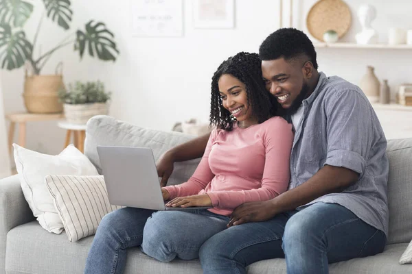 Conceito de Lazer de Quarentena. feliz casal preto relaxante com laptop em casa — Fotografia de Stock