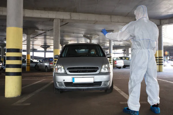 Hombre en traje de coronavirus detener a la mujer en el coche para medir la temperatura — Foto de Stock