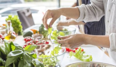 Tanınmayan kadın vitamin dolu taze salata yapıyor.