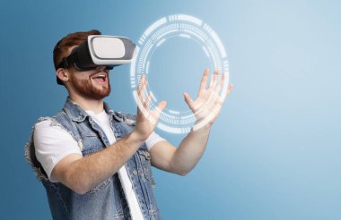 Mutlu genç adam sanal ekrana dokunuyor mavi arka planda, boş alanda. Kolaj