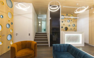 Resepsiyonlu boş salon ve kanepeli bekleme salonu.