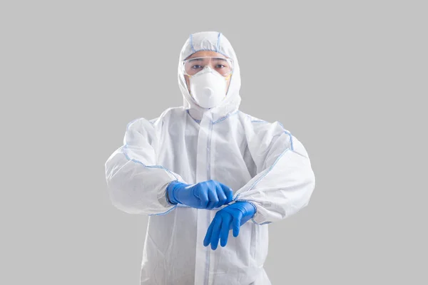 Борьба с коронавирусом. Азиатский мужчина надевает защитный костюм — стоковое фото