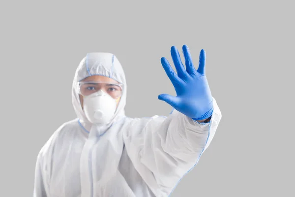 Man in protective suit makes stop sign with hand — Stock Photo, Image