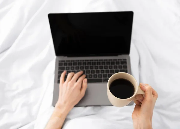Hands typing on laptop in the morning on a white pillow bed — Stock Photo, Image
