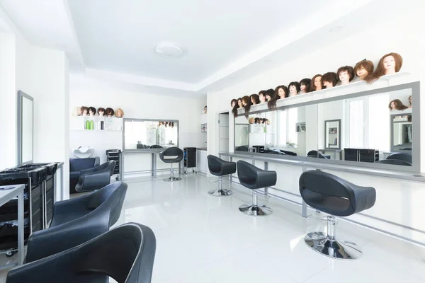 Variété de coiffures sur mannequins dans le salon de coiffure — Photo