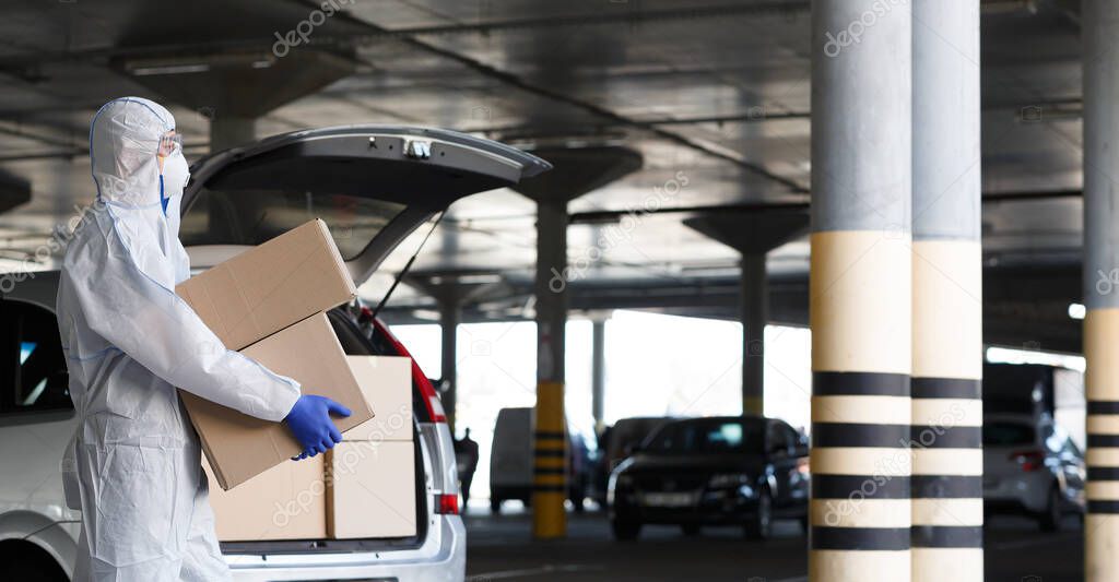 Man in protective suit delivering essential goods to people