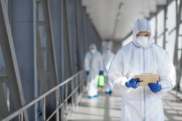 Head of medical group reading rules how to disinfecting outdoor accommodation — Stock Photo, Image