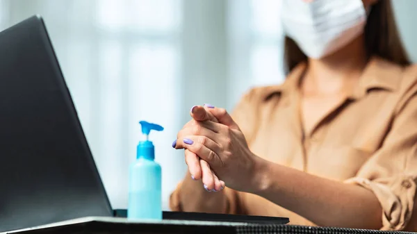 Vrouw met een beschermend masker en ontsmettingsmiddel — Stockfoto