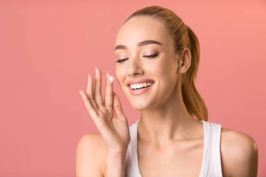 Cilt Gıdası İçin Yüz Kremi Uygulayan Mutlu Kadın, Pembe Arkaplan