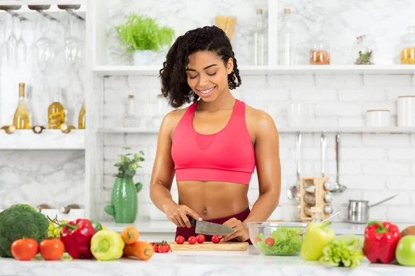 Schöne junge Afro-Frau bereitet Gemüsesalat zu — Stockfoto