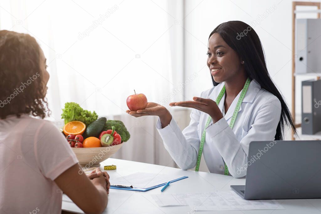 Positive african nutritionist recommending fresh fruits to eat
