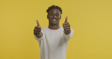 Neşeli Afrikalı Amerikalı adam başparmağını kaldırıyor.