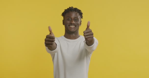 Веселый африканский американец, показывающий большие пальцы — стоковое видео