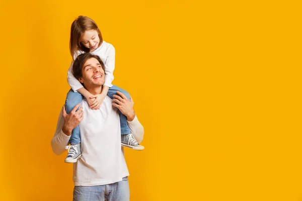 Pai feliz carregando sua alegre filhinha nos ombros — Fotografia de Stock