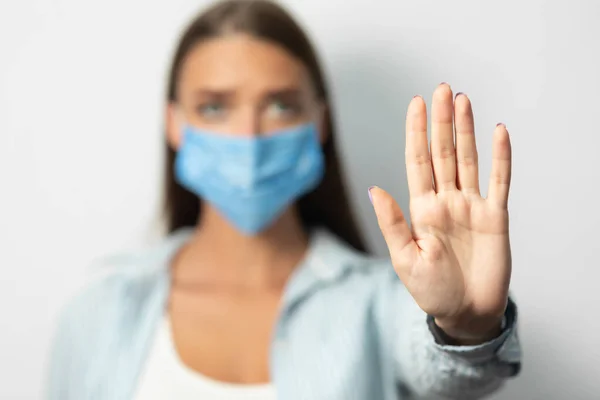 Meisje in het masker Gesturing Stop met het verbieden van iets over witte achtergrond — Stockfoto