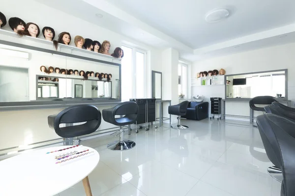 Many mannequins heads with hairstyles in barbershop — Stock Photo, Image