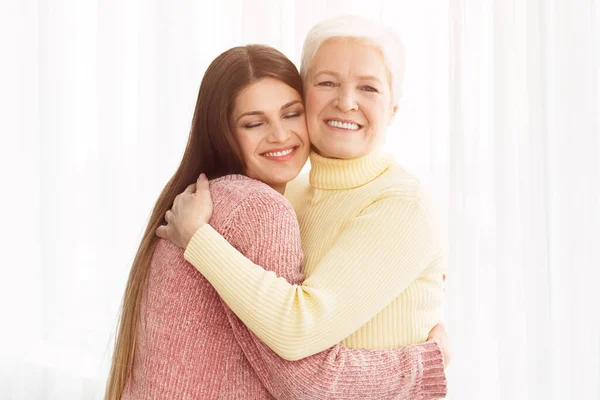 Warme knuffel. Jonge dochter omhelst haar moeder — Stockfoto