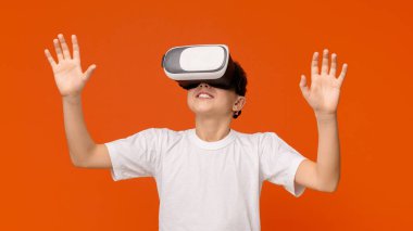 Sanal gerçeklik kulaklığında 3 boyutlu teknolojinin keyfini çıkaran genç bir çocuk.