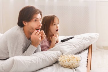 Bekar baba, küçük kızıyla korku filmi izliyor.
