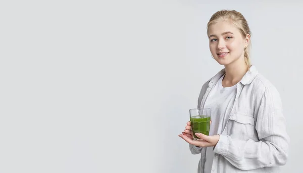 Fille buvant du jus de légumes frais vert de désintoxication sur gris — Photo