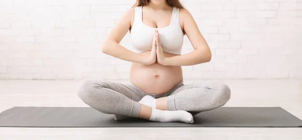 Mulher grávida praticando exercícios de relaxamento em casa — Fotografia de Stock