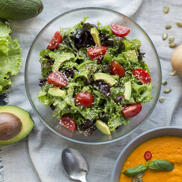 Soupe à la crème chaude de citrouille et salade fraîche sur la table de cuisine — Photo