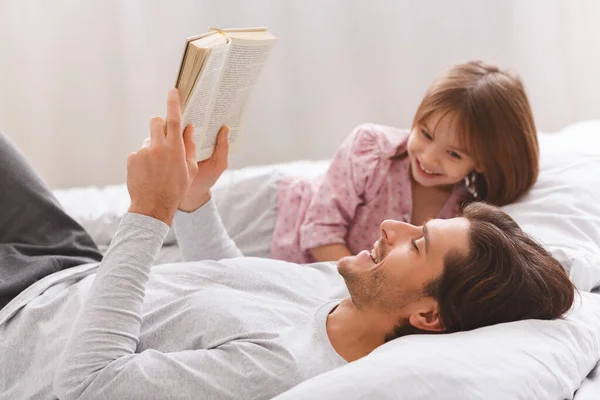 Young father reading book to his little happy daughter — Stock Photo, Image