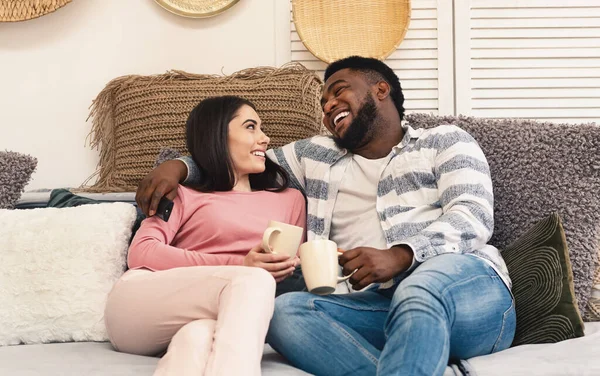 Hombre y mujer se sientan en el sofá y se ríen — Foto de Stock