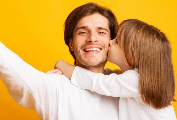 Menina beijando seu pai feliz, fazendo selfie juntos — Fotografia de Stock