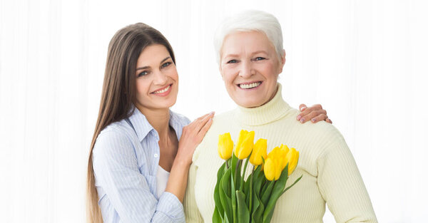 Happy mother and daughter with bouquet of tulips