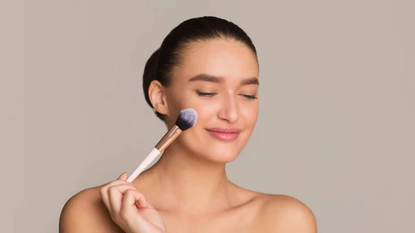 Smiling caucasian young woman using her brush — Stock Photo, Image