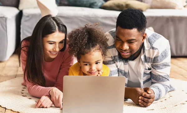 Família multirracial olhando para laptop durante a quarentena — Fotografia de Stock