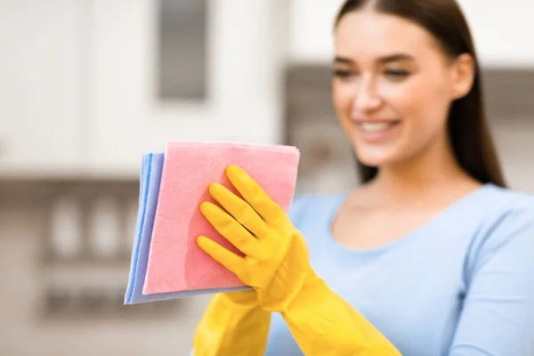 Młoda kobieta trzyma szmaty do sprzątania kuchni — Zdjęcie stockowe