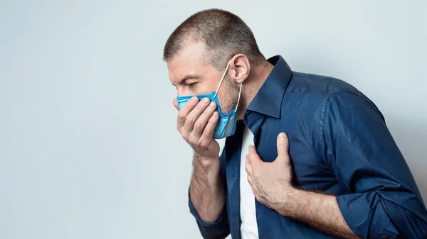 Uomo tosse avendo difficoltà a respirare in piedi su sfondo grigio, Panorama — Foto Stock