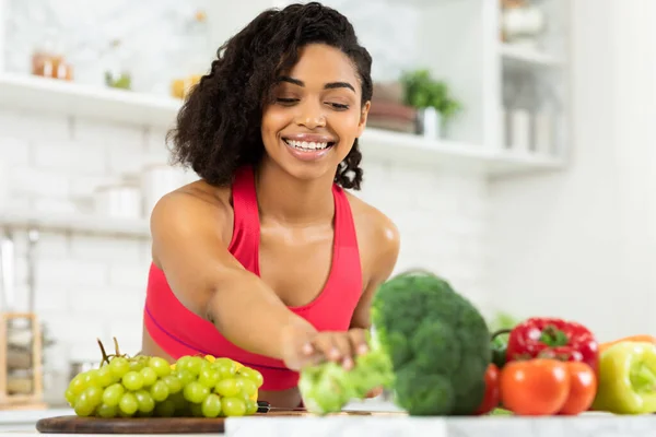 Feliz joven mujer negra preparando ensalada de verduras —  Fotos de Stock