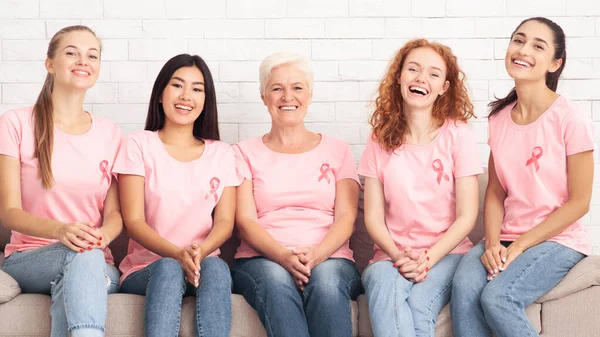 Damer i cancer T-shirts sittning under support gruppmöte inomhus — Stockfoto
