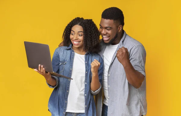 Souriant couple afro-américain regarder les sports sur ordinateur portable ensemble et encourager — Photo