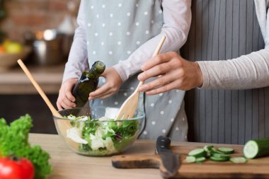 Baba ve küçük kız mutfakta sebze salatası pişiriyorlar.