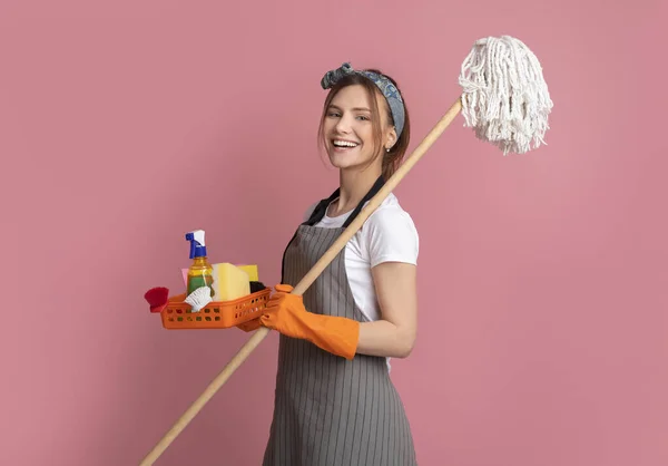 Pulizia professionale. Sorridente giovane donna con forniture per la casa nelle mani — Foto Stock