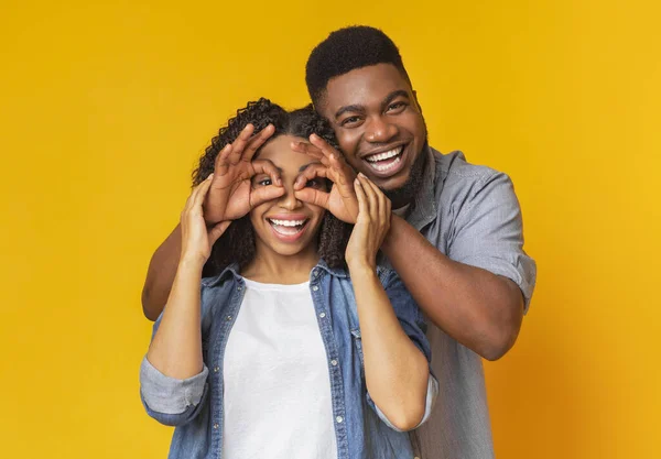 Alegre afro novio hacer divertido gafas a risa novia — Foto de Stock