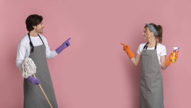 Boşluğu işaret eden Ellerinde Temizlik Aletleri olan Mutlu Çift