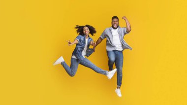 Neşeli çift birlikte takılıyor, havaya atlıyor ve barış işareti gösteriyor.