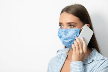 Tıbbi Maskeli Kız Beyaz Arkaplanda Telefonda Konuşuyor
