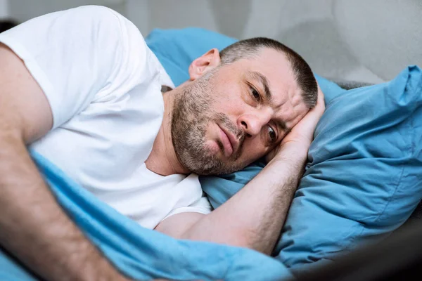 Felnőtt férfi fekszik az ágyban Nem tud aludni otthon — Stock Fotó