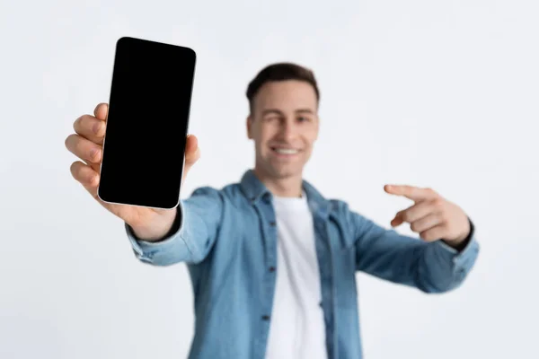 Kerl zeigt mit Finger auf leeren Bildschirm des Smartphones — Stockfoto